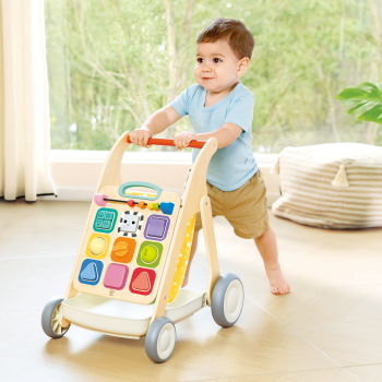 Niño caminando con el andador evolutivo Hape y sujetándose a la barra naranja