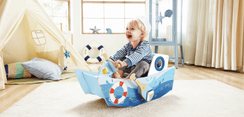 Niño jugando con el barco mecedor del Capitán de Hape