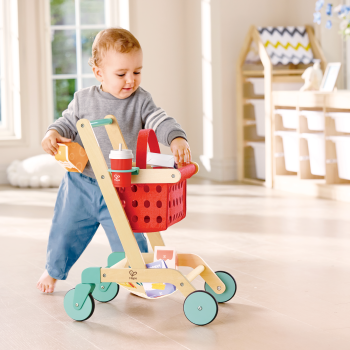 Niño jugando con el carrito de la compra infantil Hape