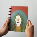 Portada de la libreta ilustrada Reina Tierra de Nazaret Moreno con retrato de mujer de cabello verde sobre fondo naranja