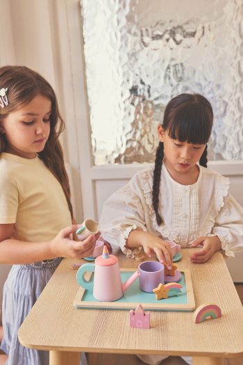 : Dos niñas jugando juntas con el set de té de madera Magic World de Monnëka. Título: Juego simbólico con el set de té Magic World.